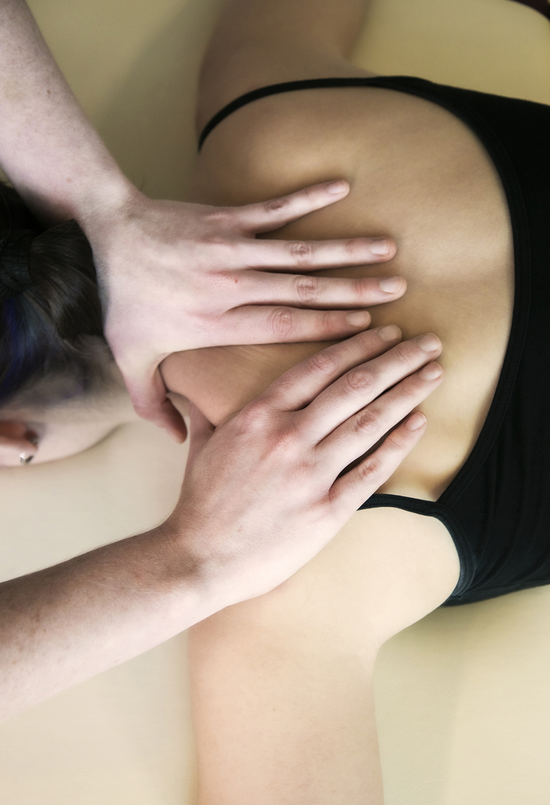 Close up of healthcare practitioners hands massaging dancers sholder Close up of healthcare practitioners hands massaging dancers sholder