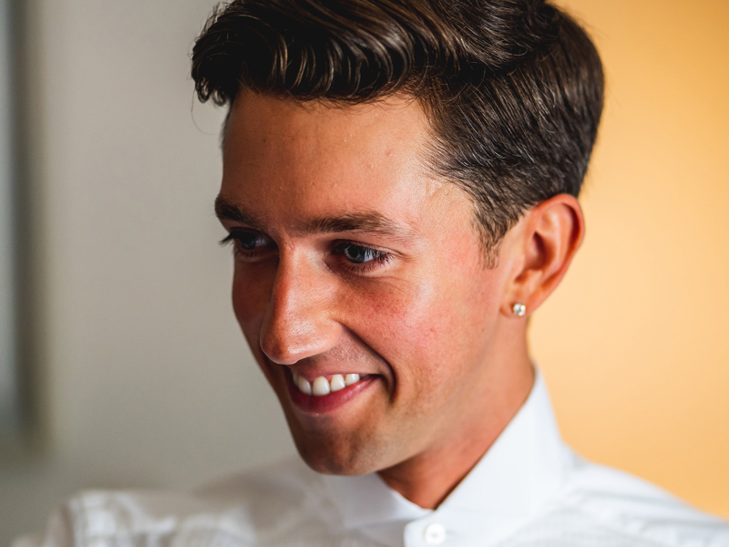 Headshot of Sonny Adam. White male looking down wearing white shirt in front of yellow background Headshot of Sonny Adam. White male looking down wearing white shirt in front of yellow background