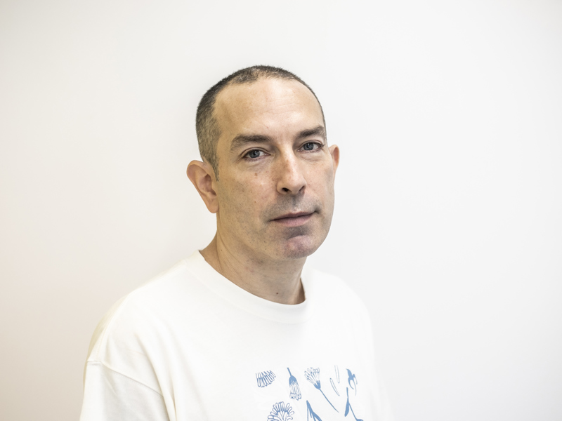 Headshot of Barny Darnell. White male with shaved head and white t-shirt with white background Headshot of Barny Darnell. White male with shaved head and white t-shirt with white background